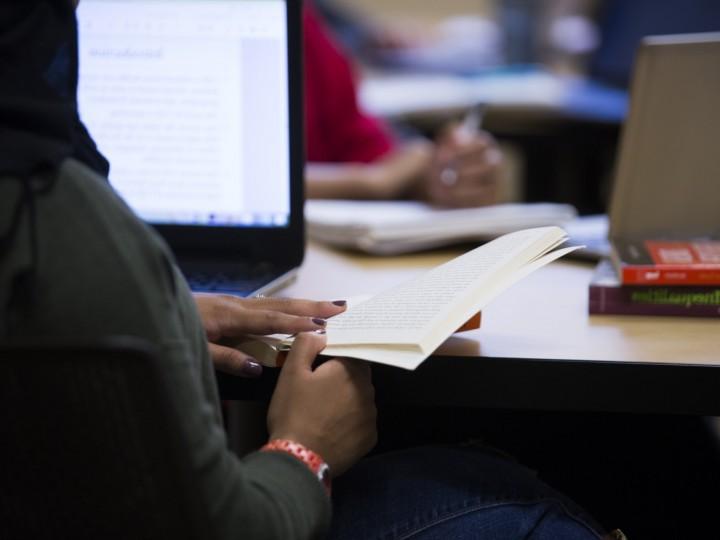 A student holds open a book during class